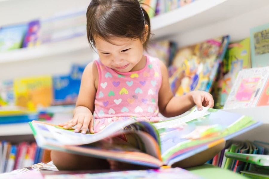 female-student-reading-a-book-in-a-classroom-book-nook-concept