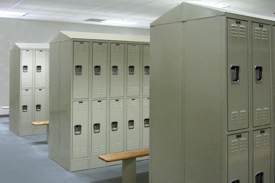 Rows of beige Hallowell double-tier steel lockers with recessed door handles and ventilation slots in a locker room with wooden benches.