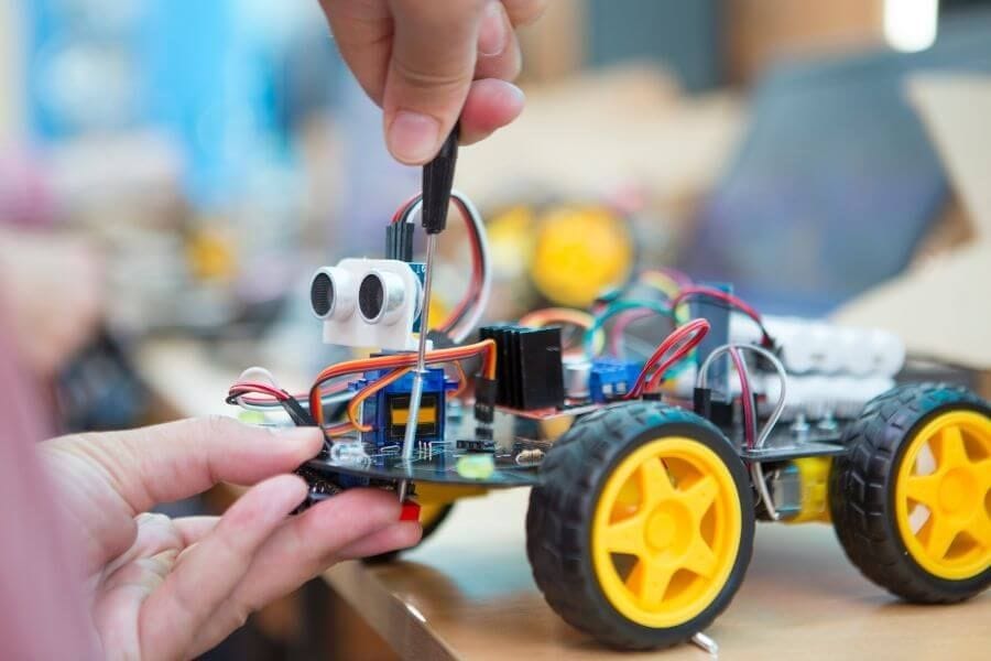 Robotics club student tinkering with robot project 