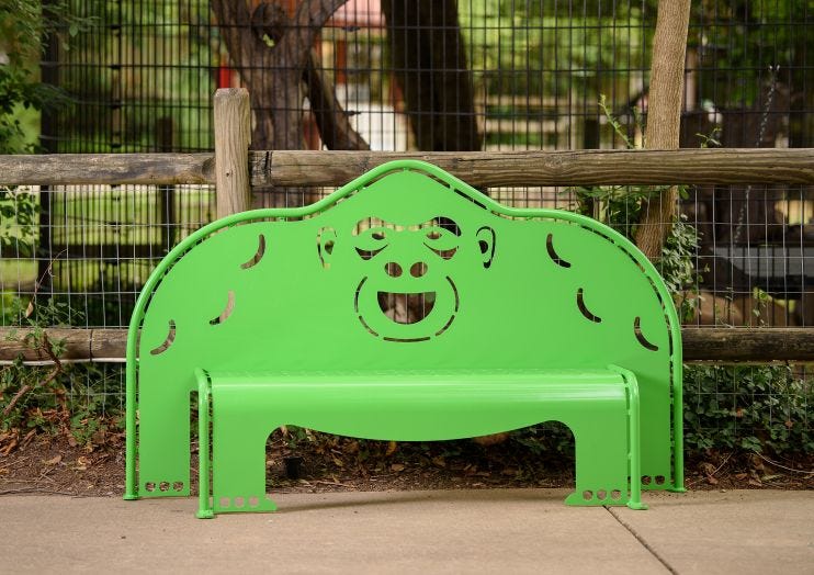 Brightly colored green outdoor bench in the shape of a gorilla. 