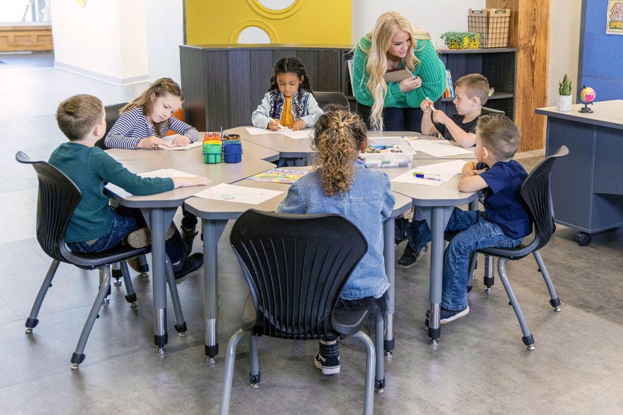 Worthington Direct Students working in a small group at clustered collaborative desks with shared supplies.