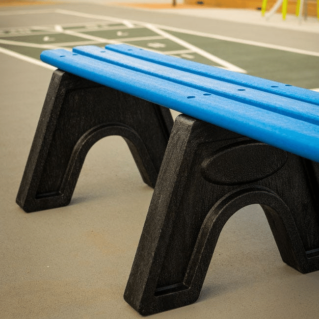 Close-up of an outdoor bench with a bright blue seat atop a black frame. 