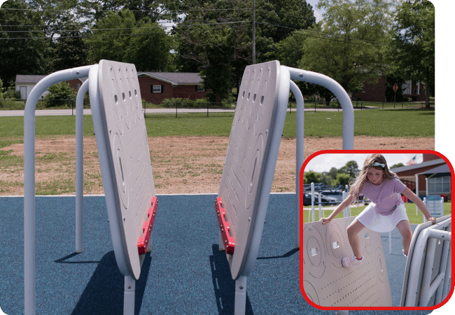 Worthington Direct Elementary student straddling an angled piece of physical equipment outdoors on her school's campus.