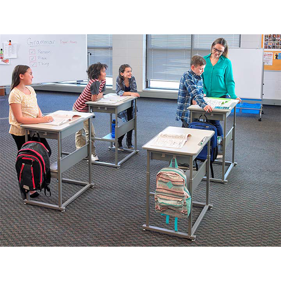 School classroom showing students and a teacher at stand-up desks .