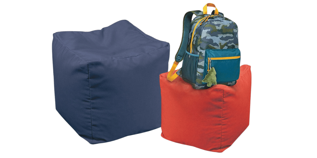 Navy blue and orange square ottomans placed side by side with a student's backpack placed on top of one. 