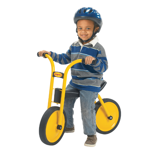 Young preschooler riding on a balance bike. 