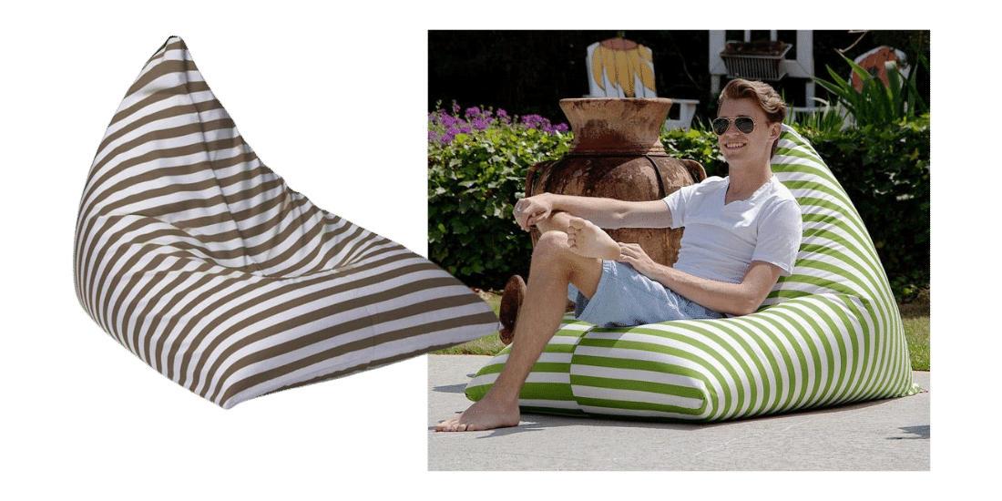 Man with sunglasses on lounging outdoors on an oversized green and white striped beanbag.