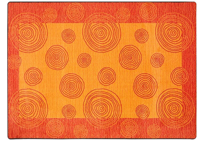 Worthington Direct Bright orange and burnt orange classroom rug featuring circular patterns of varying sizes throughout the carpet.