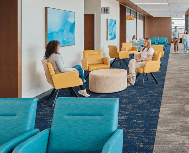 Patients and guests sitting in reception seating at a medical facility. 